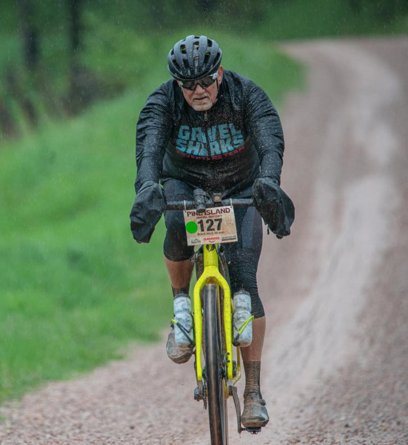 Load image into Gallery viewer, Cyclist on rainy, cold and mucky Gravel Race - Piney Island Gravel Odessey in Spearfish SD
